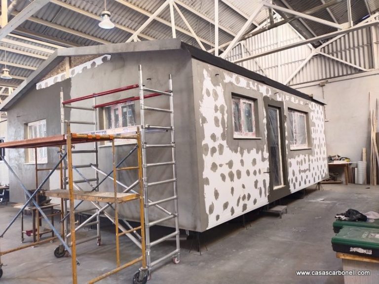 Casa prefabricada con fachada de sistema SATE en construcción. Casa prefabricada en construcción, con andamios y una estructura sin terminar.