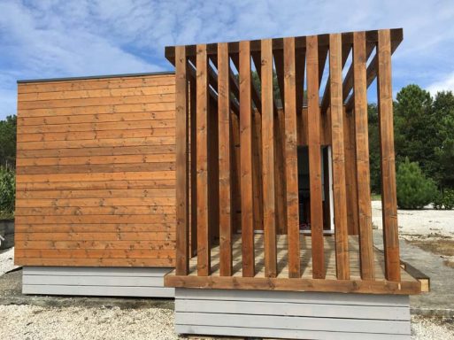 Estructura arquitectónica de casa prefabricada moderna de madera con paneles y columnas verticales.