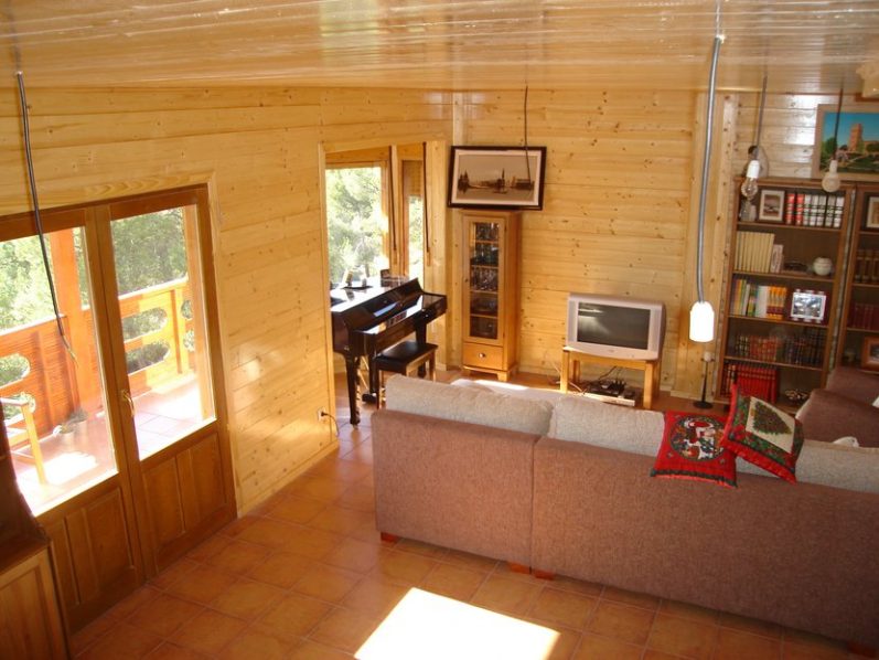 Interior de una sala de estar con muebles acogedores y una vista exterior.