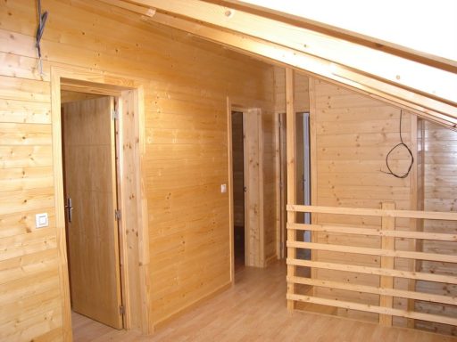 Interior de una casa de madera con puertas y barandilla.