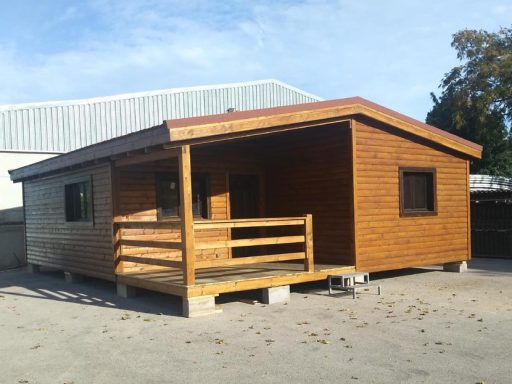 Casa prefabricada de madera de una planta con porche, en un entorno despejado y bien iluminado.