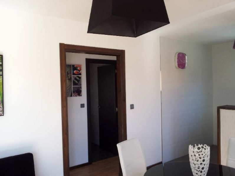 Interiores de una habitación con una puerta y lámpara colgante. Mobiliario moderno.