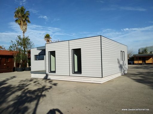 Casa prefabricada moderna de un solo piso con paredes claras y ventanas amplias.