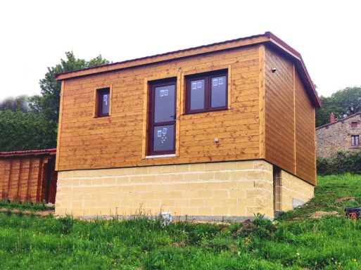 Casa prefabricada Náquera con ventanas en un terreno verde.